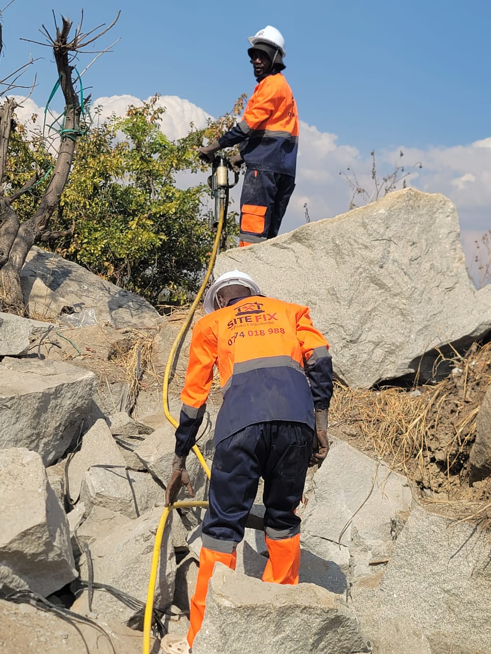Rock drilling rig operating on exposed bedrock